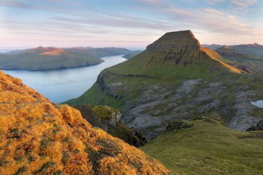 Faroe Adaları 'nın tepesinde. Güneşli bir günde yüksek dağ zirveleri manzarası. Okyanus manzaralı. Güzel panoramik manzara. Kuzey Avrupa. Seyahat kavramı