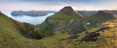 Faroe Adaları 'nın tepesinde. Güneşli bir günde yüksek dağ zirveleri manzarası. Okyanus manzaralı. Güzel panoramik manzara. Kuzey Avrupa. Seyahat kavramı