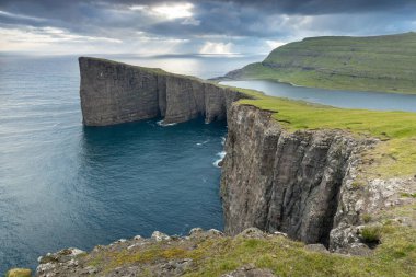 Faroe Adaları 'nın tepesinde. Güneşli bir günde yüksek dağ zirveleri manzarası. Okyanus manzaralı. Güzel panoramik manzara. Kuzey Avrupa. Seyahat kavramı