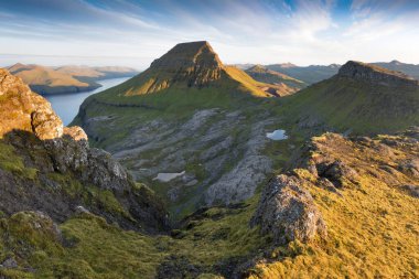 Faroe Adaları 'nın tepesinde. Güneşli bir günde yüksek dağ zirveleri manzarası. Okyanus manzaralı. Güzel panoramik manzara. Kuzey Avrupa. Seyahat kavramı