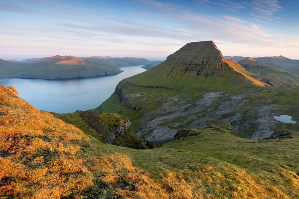 Faroe Adaları 'nın tepesinde. Güneşli bir günde yüksek dağ zirveleri manzarası. Okyanus manzaralı. Güzel panoramik manzara. Kuzey Avrupa. Seyahat kavramı