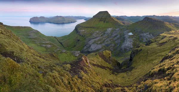 Faroe Adaları 'nın tepesinde. Güneşli bir günde yüksek dağ zirveleri manzarası. Okyanus manzaralı. Güzel panoramik manzara. Kuzey Avrupa. Seyahat kavramı