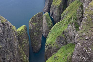 Faroe adalarındaki inanılmaz uçurumlar. Güneşli bir günde yüksek dağ zirveleri manzarası. Okyanus manzaralı. Güzel panoramik manzara. Kuzey Avrupa. Seyahat kavramı