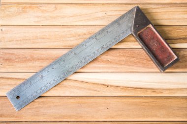 Metal açı cetvel üzerinde ahşap arka plan