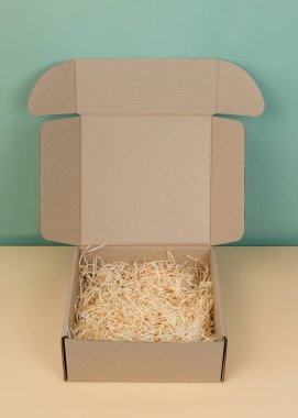 Arka planda bir yığın kahverengi karton kutu var. Boş bir karton kutu. Hediye paketleme konsepti. Eşya kutusu hediye olarak ya da tarafsız bir arkaplanda. Alışverişe. Boşluğu kopyala.