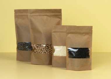 Kahverengi kraft kağıdından çanta, sarı arka planda market önü manzaralı. Gıda ve mallar için ambalaj tasarımı. Ağırlık ürünleri için pencereli paketler. Moda rengi