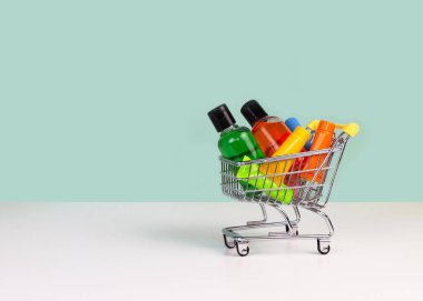 Minyatür alışveriş arabası ve kozmetik seti. Dünya tüketim günü konsepti. Kozmetik, çevrimiçi alışveriş kavramı satın almak.
