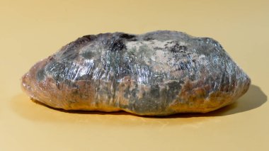 Plastik ambalajlı yeşil küflü ekmek. Yiyecek atığı konsepti. Minimalist stil.