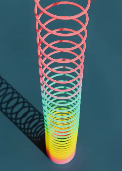 Juguete plástico colorido arco iris espiral para jugar fondo azul. —  Fotos de Stock