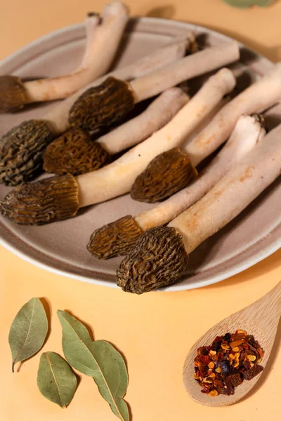 Spring wild morel mushrooms or Morchella conica. They are loaded with all kinds of vitamins and minerals, high in antioxidants, low in calories, and high in fiber and protein. On brown background.