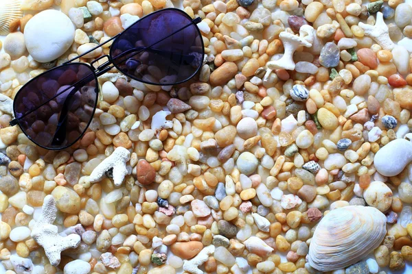 Gafas de sol en la playa de guijarros - vacaciones de verano — Foto de Stock