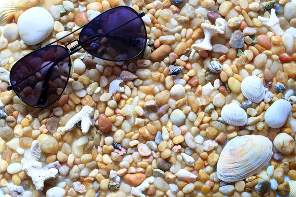 Gafas de sol en la playa de guijarros - vacaciones de verano — Foto de Stock