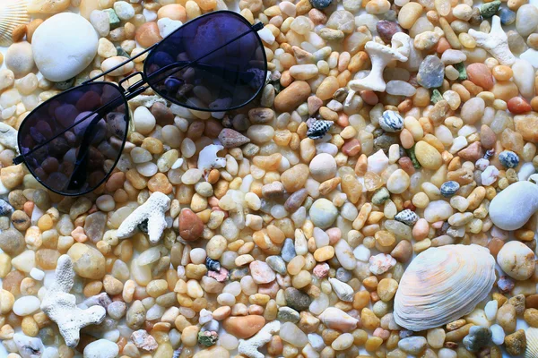 Γυαλιά ηλίου στην παραλία με βότσαλα - καλοκαιρινές διακοπές — Φωτογραφία Αρχείου