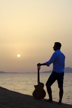 sabah güneş izlerken sahilde gitarist