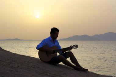 adam sahilde gitar çalmak
