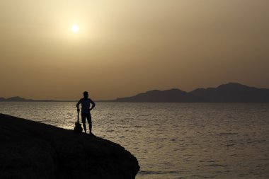 adam gitar bir uçurumun üzerinde