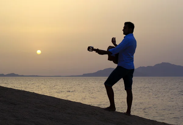 Uomo che suona la chitarra sulla spiaggia — Foto Stock