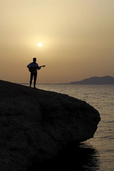 Člověk hrát na kytaru na pláži — Stock fotografie