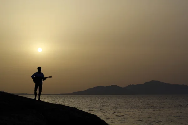 Hombre tocando la guitarra en la playa — Foto de Stock