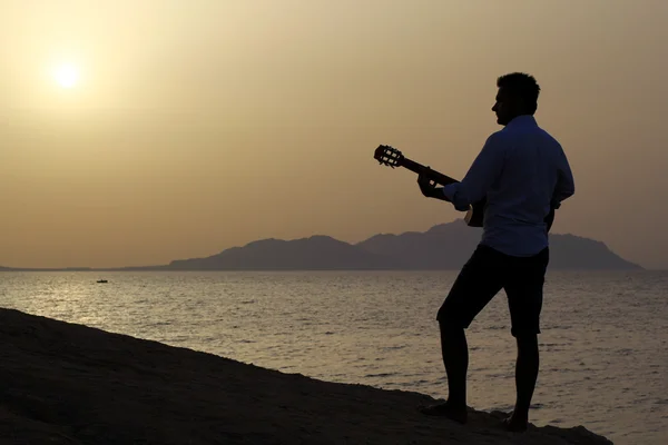 Uomo che suona la chitarra sulla spiaggia — Foto Stock