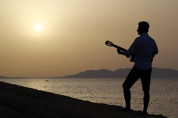 Uomo che suona la chitarra sulla spiaggia — Foto Stock