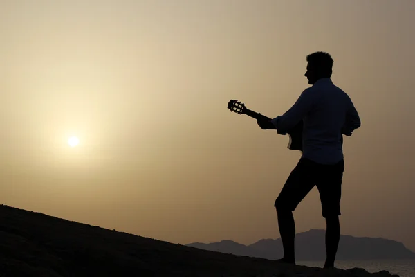 Člověk hrát na kytaru na pláži — Stock fotografie