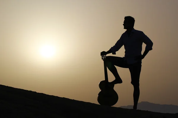 Chitarrista sulla spiaggia a guardare il sole del mattino — Foto Stock