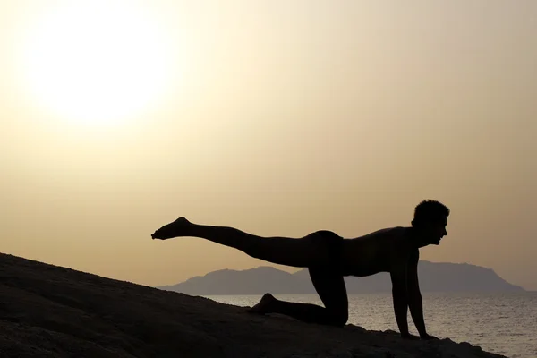 Silueta de un hombre haciendo yoga, tai chi — Foto de Stock