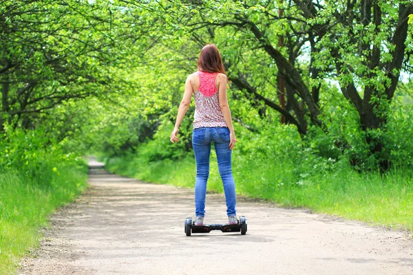 Mujer montando scooter eléctrico — Foto de Stock