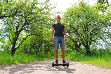 Park elektrik bir scooter sürme adam