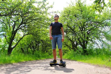 Park elektrik bir scooter sürme adam