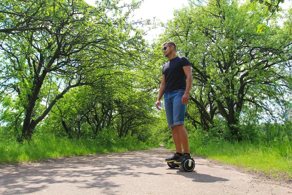 Homme chevauchant un scooter électrique dans le parc — Photo