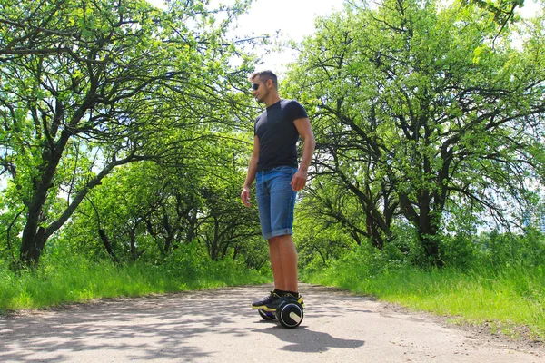 Park elektrik bir scooter sürme adam