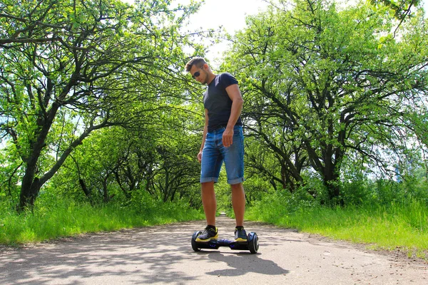 公園で電気スクーターに乗る男 — ストック写真
