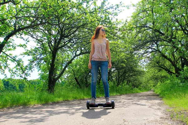 Mujer joven montando scooter giroscopio - transporte ecológico personal — Foto de Stock