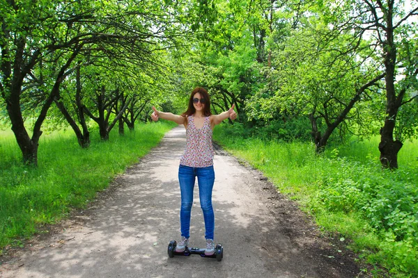 Mujer joven montando scooter giroscopio - transporte ecológico personal — Foto de Stock