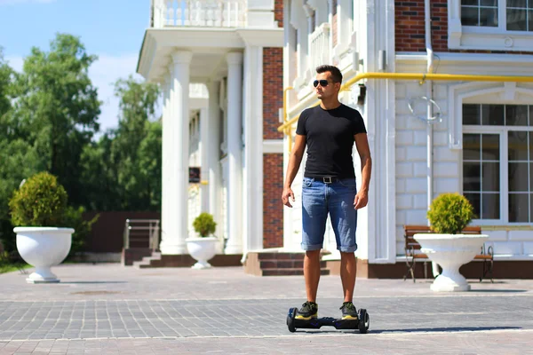 Jovem homem montando scooter elétrico — Fotografia de Stock