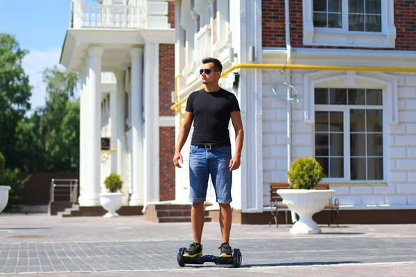 Jovem homem montando scooter elétrico — Fotografia de Stock