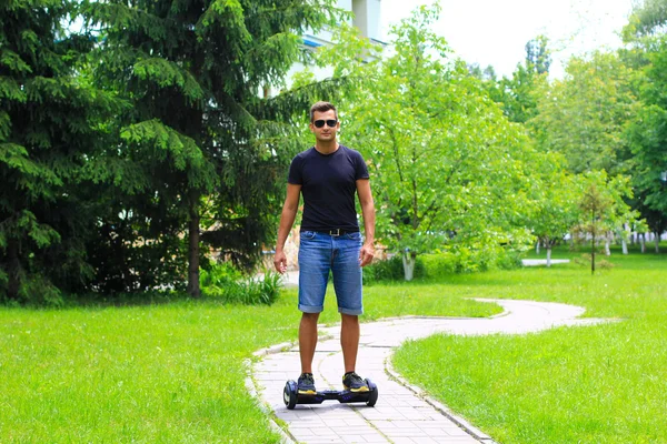 Genç adam akıllı bir denge tekerlekli sürme yerleştirmek — Stok fotoğraf