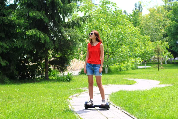 Jonge vrouw met een elektrische scooter rijden — Stockfoto
