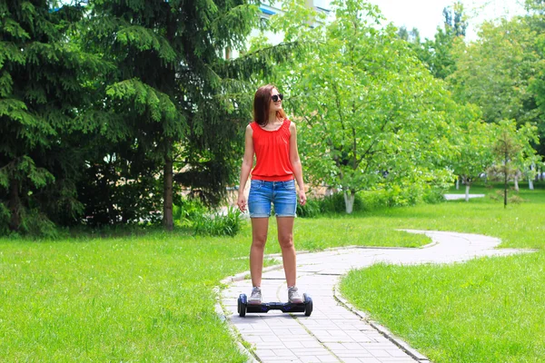 Jovem mulher montando uma scooter elétrica — Fotografia de Stock