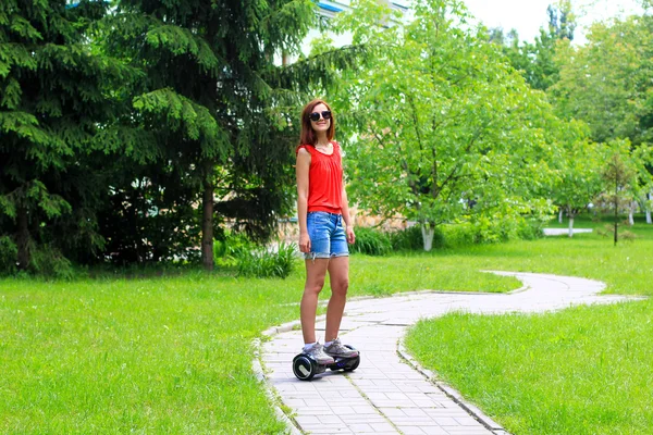 Jovem mulher montando uma scooter elétrica — Fotografia de Stock