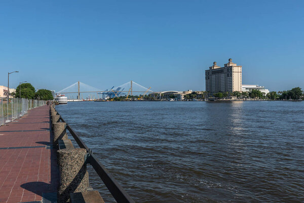 Savannah, Georgia, USA - May 24, 2025: River Waterfront Promenade along the Savannah river. Georgia Riverside Walk. Talmadge Memorial Bridge Skyline