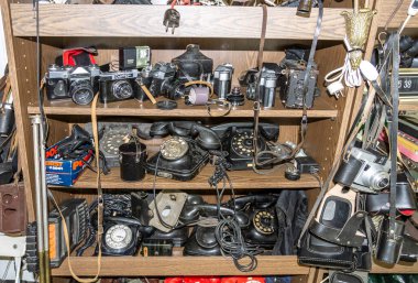 Budapeşte, Macaristan - 1 Eylül 2014: Ecseri Bit Pazarı 'ndaki Wooden Raflarında Vintage Cameras ve Rotary Telefonları Koleksiyonu. Retro Teknoloji Görüntüsü