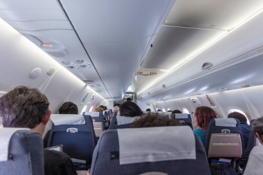 Ilulissat, Grönland - 17 Temmuz 2016: Yolcularla birlikte ticari uçak kabininin iç görünümü. Koridor Perspektifi