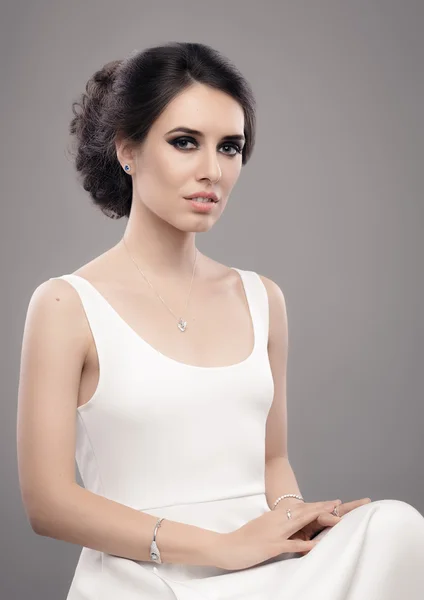 Belle femme élégante en robe blanche portant des bijoux — Photo