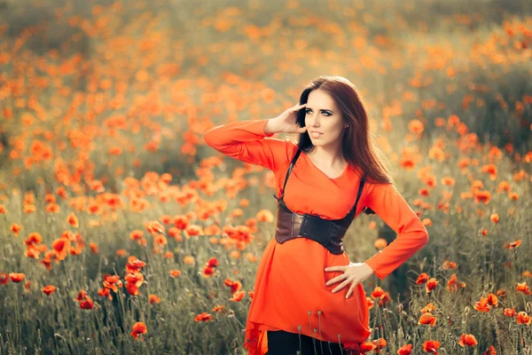 Hermosa mujer en un campo de amapolas — Foto de Stock