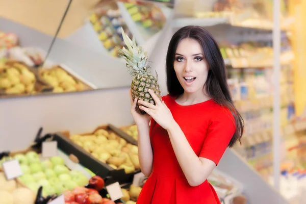 Mulher engraçada com frutas de abacaxi no supermercado — Fotografia de Stock