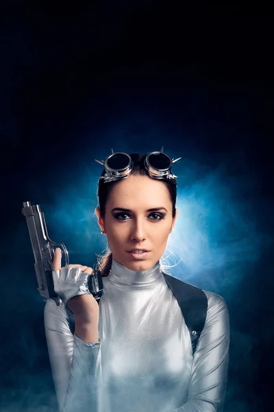 Жінка в срібному космічному костюмі тримає пістолет — стокове фото