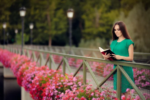女性の花で橋の上の本を読んで — ストック写真